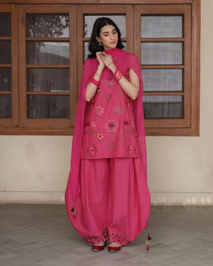 Woman in vibrant pink floral embroidered salwar kameez and dupatta, traditional outfit style
